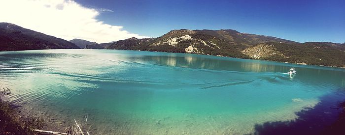 Swimming pool by lake against sky