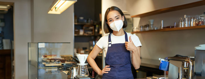 Portrait of young woman standing at home