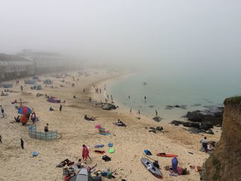 High angle view of people at beach in foggy weather