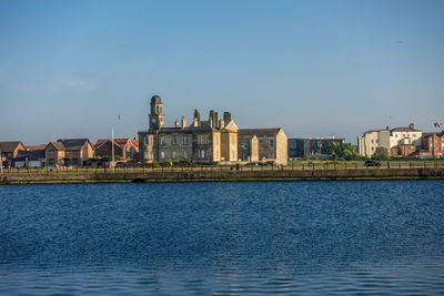 Buildings in city against clear blue sky