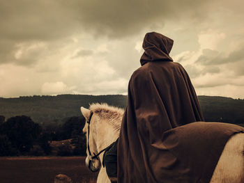 Side view of horse standing on field against sky