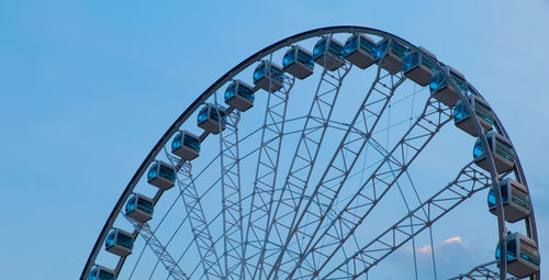 Low angle view of ferris wheel against clear blue sky