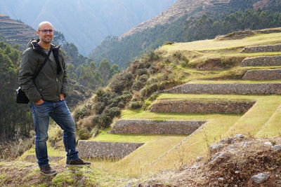 Full length portrait of mid adult man standing against mountains