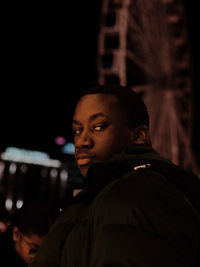 Side view of man looking away against black background