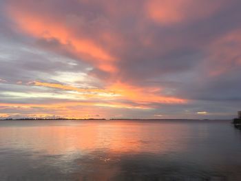 Scenic view of sea against cloudy sky at sunset