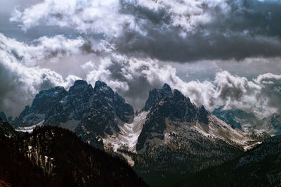 Scenic view of mountains against cloudy sky during winter