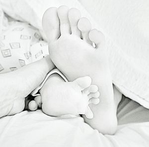 Close-up of baby lying on bed