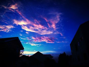 Low angle view of silhouette buildings against sky