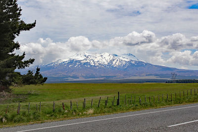 Scenic view of road by mountains against sky