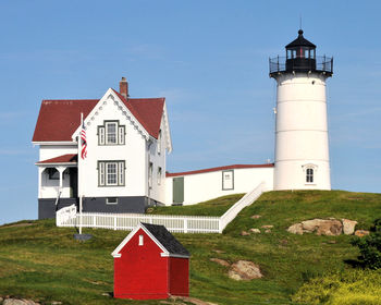 Lighthouse amidst buildings against sky