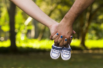 Close-up of hands holding baby shoes