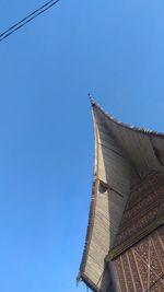 Low angle view of roof against building against clear blue sky