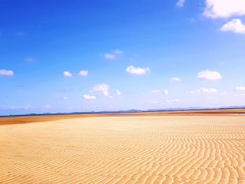 Scenic view of desert against blue sky