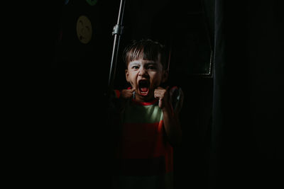 Portrait of girl shouting in darkroom