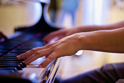 Midsection of man playing piano