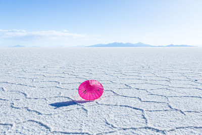 Pretty pink parasol set on the uyuni salt flat during a sunny day, bolivia