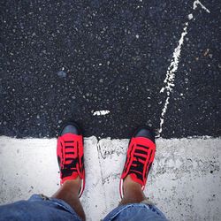 Low section of man standing on road