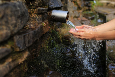 Cropped image of woman holding fountain in park