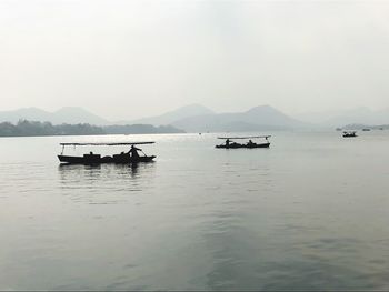 Boats in sea against sky