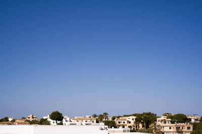 View of cityscape against clear blue sky