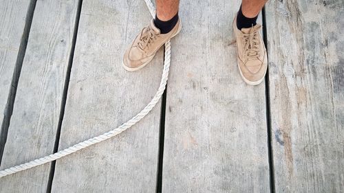 Low section of man standing on wood