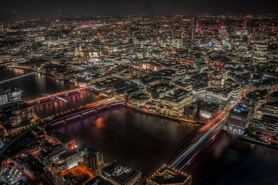 High angle view of illuminated city by river at night