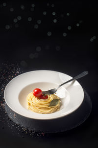 Plate with spaghetti and cherry tomatoes with illuminated backgr