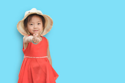 Portrait of smiling girl standing against clear blue sky