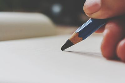 Close-up of person writing with pencil