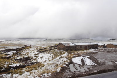 Scenic view of snow covered land against sky