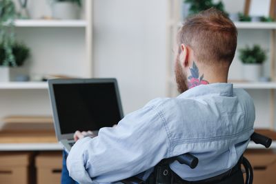 Side view of man using laptop at office