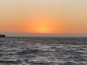Scenic view of sea against orange sky