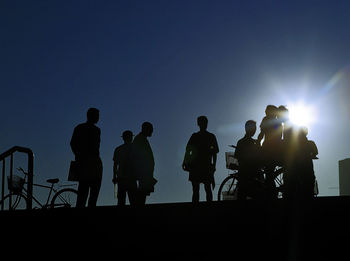 Silhouette people standing against sky