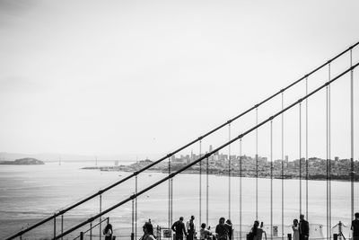 Group of people on bridge over sea