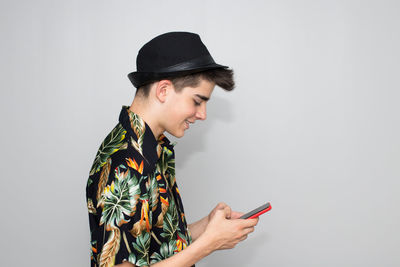 Young woman using mobile phone against white background