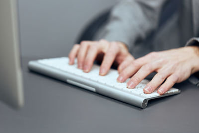 Midsection of businessman using laptop on table