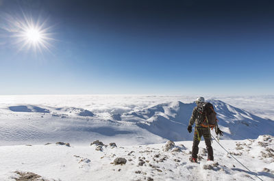 Man on snowcapped landscape against clear sky