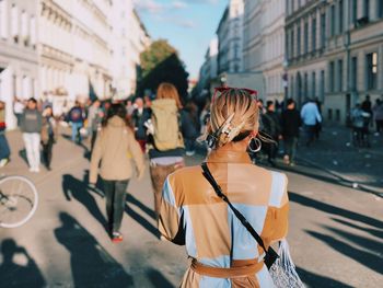 Rear view of woman standing on city street