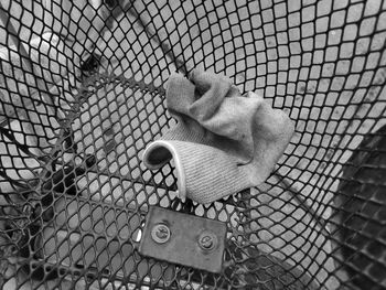 High angle view of stuffed toy seen through chainlink fence