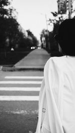 Rear view of woman standing on road