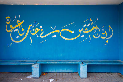 Graffiti on wall against blue sky