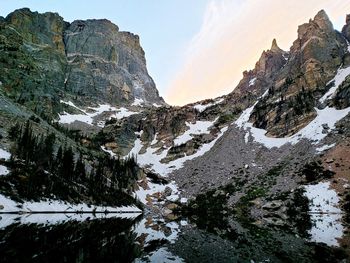 Clear waters of emerald lake as the sun disappears behind hallett peak