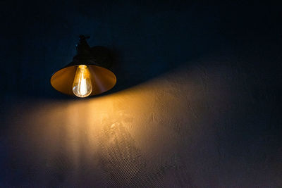 Close-up of illuminated lamp hanging on wall
