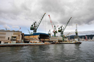 Commercial dock by sea against sky