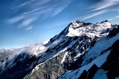 Snowcapped mountains against blue sky on sunny day