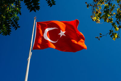 Low angle view of flag against blue sky