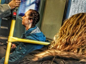 Side view of young woman sitting in train