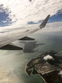 Close-up of airplane flying over sea against sky