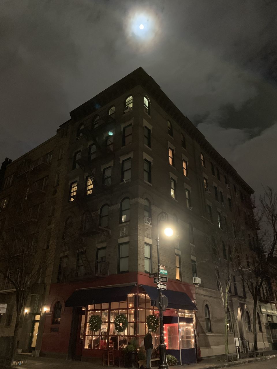 LOW ANGLE VIEW OF ILLUMINATED BUILDINGS AGAINST SKY AT NIGHT