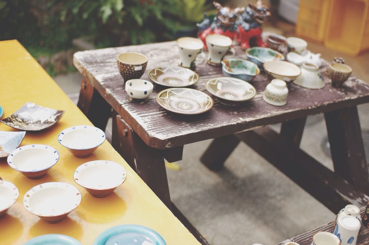 table, indoors, food and drink, high angle view, drink, freshness, still life, food, plate, refreshment, bowl, coffee cup, spoon, large group of objects, cup, coffee - drink, wood - material, arrangement, sweet food, variation